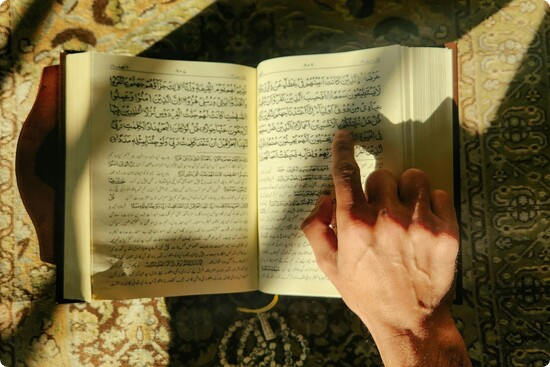 A Muslim man tracing on Quran