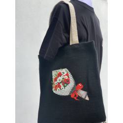 Perfect Gift Introducing our exclusive Olives & Poppies Tote Bag.&nbsp;This beautiful black tote bag, is made from 100% organic jute and comes complete with contrasting handles in a natural colour. The focal point of this unique tote bag is a captivating image featuring a delicate arrangement of poppies and olives wrapped in paper, adorned with a keffiyeh-inspired design. The rich symbolism of poppies and olives, coupled with the keffiyeh pattern, creates a visual narrative advocating for peace in solidarity with the people of Palestine. N.B: As all apparel is printed in-house please allow up to 2 weeks for delivery. Should you need the items sooner, please contact us and we do our best to help you Insha Allah